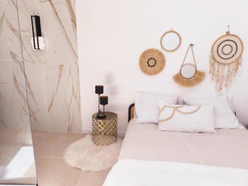 a bedroom with a bed with white pillows and mirrors at Villa MOOJŸ in Carcès