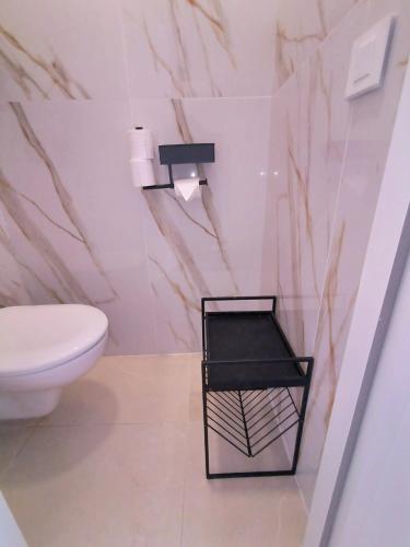 a bathroom with a white toilet and a black stool at Villa MOOJŸ in Carcès