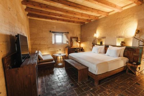a bedroom with a bed and a television in it at Millstone Cave Suites Hotel in Uchisar