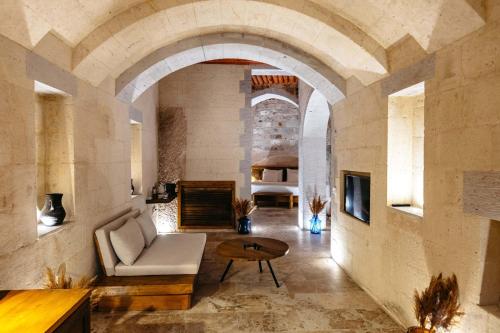 a living room with an archway and a couch and a table at Millstone Cave Suites Hotel in Uchisar