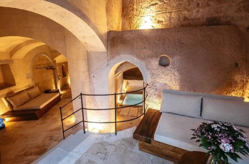a living room with a couch and a fireplace at Millstone Cave Suites Hotel in Uchisar