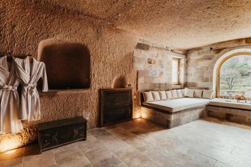a living room with a bed and a window at Millstone Cave Suites Hotel in Uchisar