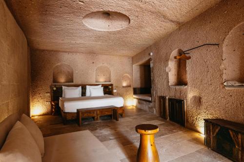 a bedroom with a bed and a fireplace in a room at Millstone Cave Suites Hotel in Uchisar