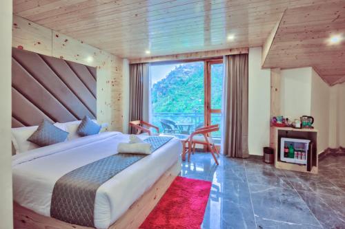 ein Schlafzimmer mit einem großen Bett und einem großen Fenster in der Unterkunft MRPS Eco Eden Resort nd Spa manali in Manali