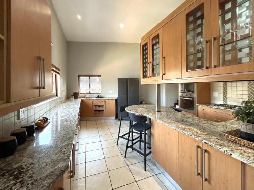 a kitchen with wooden cabinets and a counter top at Fish Eagle Manor in Warmbaths