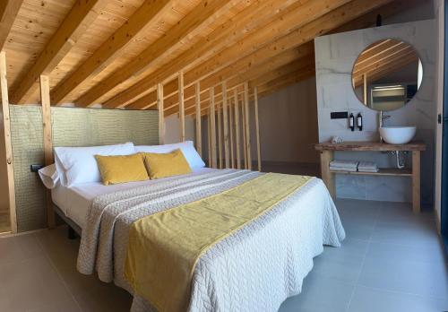 a bedroom with a large bed with a wooden ceiling at La LIPA SUITES con piscina privada in Almáchar