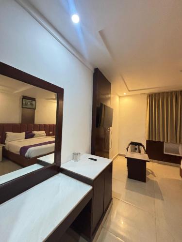 a hotel room with a bed and a mirror at Hotel Drive Inn in Haridwār