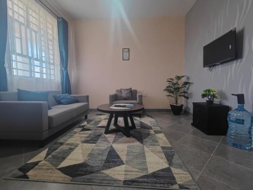 ein Wohnzimmer mit Sofa und Tisch in der Unterkunft A Oasis Taveta in Taveta