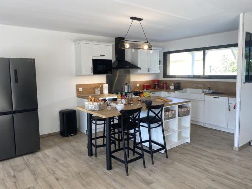 une cuisine avec des armoires blanches et un réfrigérateur noir dans l'établissement Holiday Home Les lilas by Interhome, à Portbail