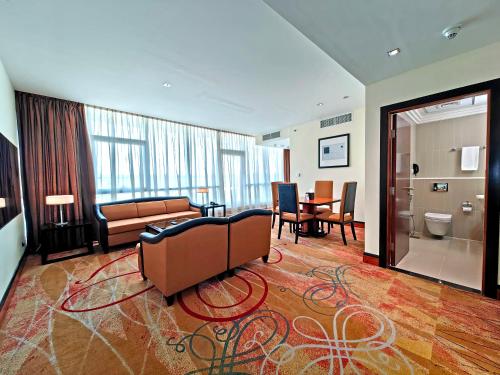 a living room with a couch and a table at Millennium Airport Hotel Dubai in Dubai