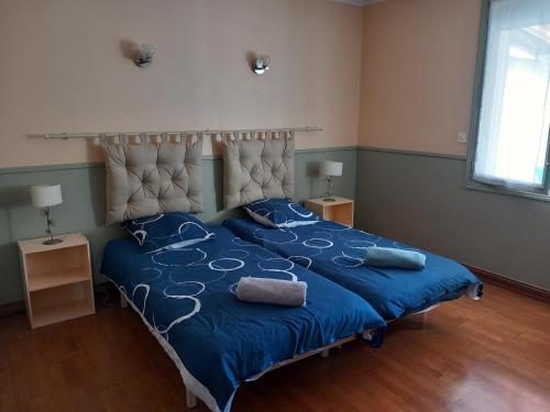 a bedroom with a bed with blue sheets and blue pillows at Maison à 100m de la plage in La Turballe