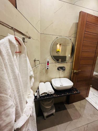 ein Badezimmer mit Waschbecken, Toilette und Spiegel in der Unterkunft Pooja O Dine in Jagādhri