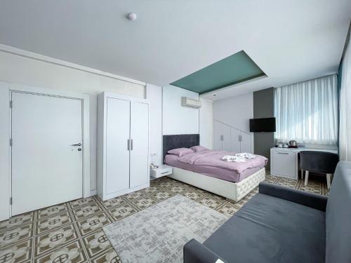 a bedroom with a pink bed and a desk at Berrak Su Hotel in Antalya