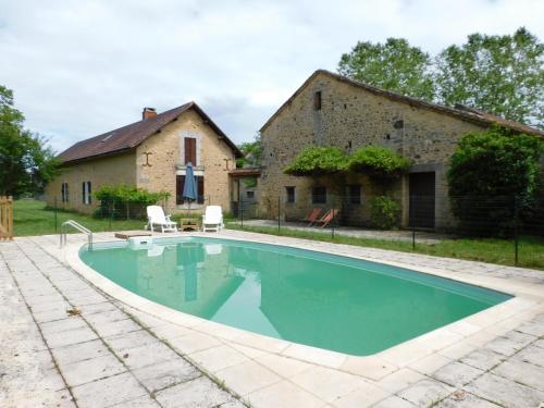 une piscine devant un immeuble dans l'établissement Les Salveyries en Dordogne Maison de campagne avec piscine et grands espaces, à Allès-sur-Dordogne