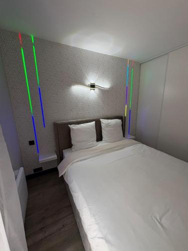 une chambre avec un grand lit blanc avec des lumières colorées dans l'établissement Apartment in a hotel residence, à Toulouse