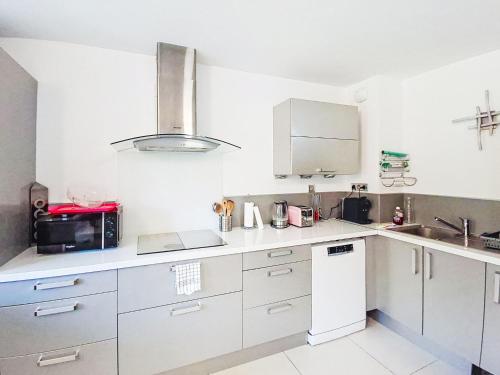 une cuisine avec des armoires blanches et un évier dans l'établissement Apartment Les Oliviers by Interhome, à Six-Fours-les-Plages