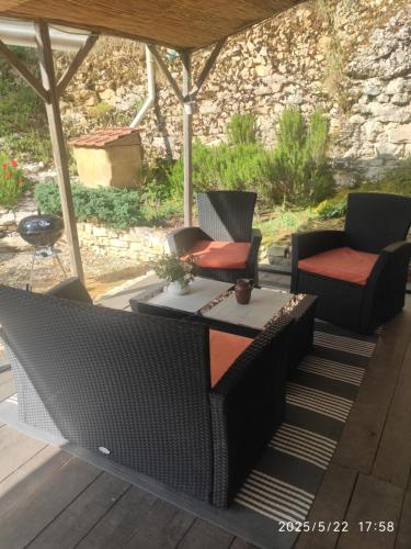Un patio con dos sillas y una mesa en una terraza. en La chaudière, en Dégagnac