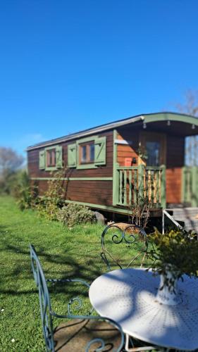 une table et des chaises devant une maison dans l'établissement La roulotte en Zordanie, à Sajas