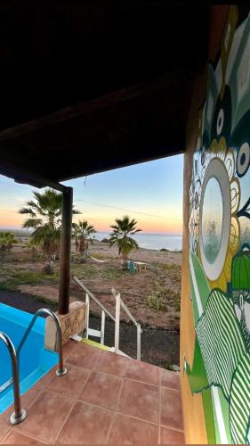 a view of the beach from the porch of a house at Adeje - TwinFin Hostel & Surf Yoga Camp in Callao Salvaje