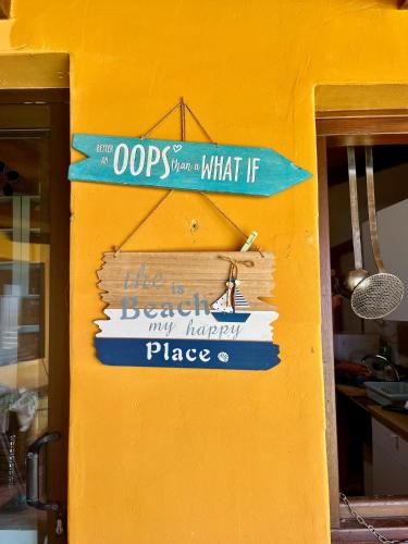 a sign on the side of a yellow wall at Adeje - TwinFin Hostel & Surf Yoga Camp in Callao Salvaje