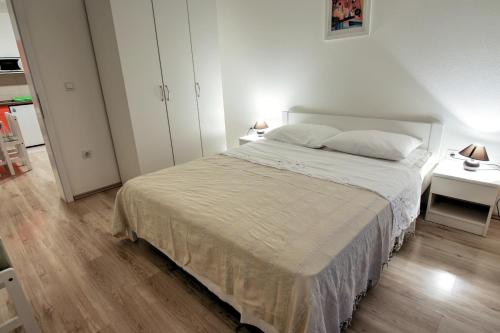 ein Schlafzimmer mit einem großen Bett und zwei Nachttischen in der Unterkunft Apartments Tomas in Senj