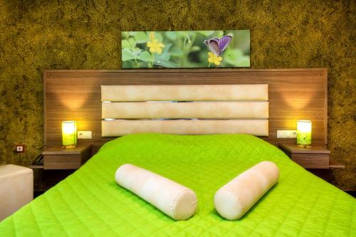 a bedroom with a green bed with two white pillows at Garden in Limenaria