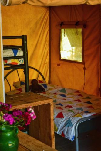 une petite pièce avec un lit et une fenêtre dans l'établissement Juliette Tentvakanties, à Saint-Antonin