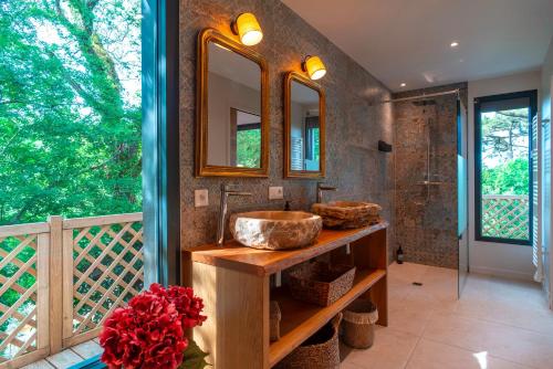une salle de bain avec un lavabo et deux miroirs dans l'établissement Le Rivage de Carnac - Vue mer proche plage, à Carnac