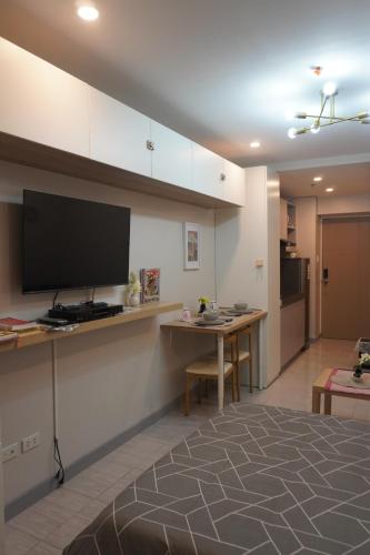 a living room with a flat screen tv and a table at Quezon City Apartment 2 Condo-Hotel with Pool View in Manila