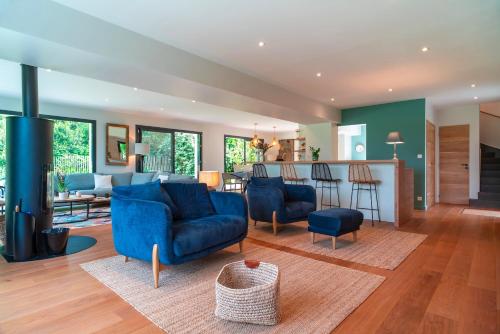 Il comprend un salon doté d'un mobilier bleu et une cuisine. dans l'établissement Le Rivage de Carnac - Vue mer proche plage, à Carnac