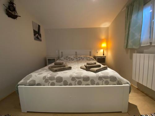 une chambre avec un grand lit blanc avec des serviettes dessus dans l'établissement Maison Agatha, à La Garde-Freinet