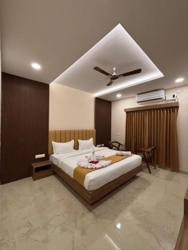 a bedroom with a large bed with a ceiling fan at Hotel Saesha International in Rāmeswaram