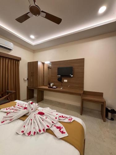a bedroom with a bed with a flat screen tv at Hotel Saesha International in Rāmeswaram