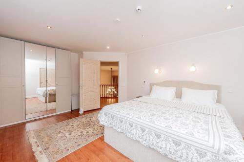 a white bedroom with a large bed and a bathroom at Luxury Villa in Pärnu, walking distance from the beach and city centre in Pärnu