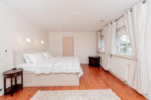a white bedroom with a bed and a window at Luxury Villa in Pärnu, walking distance from the beach and city centre in Pärnu