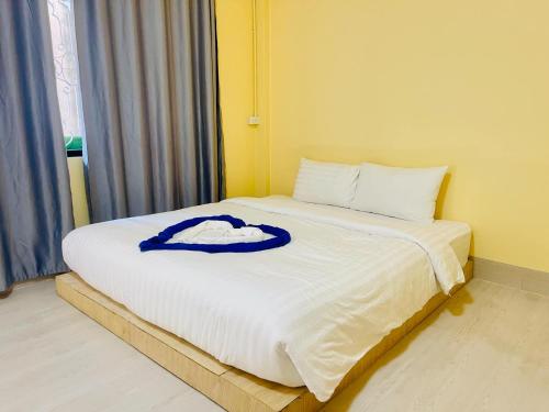 a bed with a blue robe on top of it at Lamoon Thungsao in Sathani Khlong Rian
