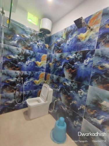 a bathroom with a painting on the wall with a toilet at Hotel Dwarkadhish Tarapith in Tarapith