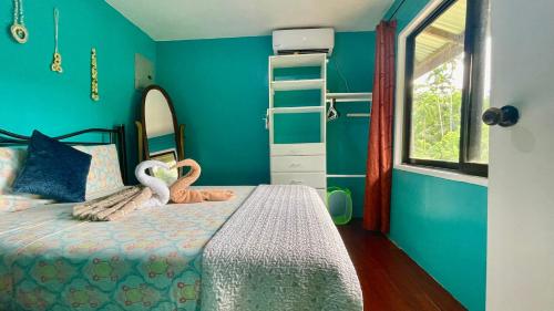 a bedroom with a bed with swans on it at Ngermid Oasis - 2 BD & 1 BA Cozy Cottage in Koror