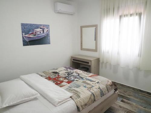 - une chambre avec un lit et une photo de bateau dans l'établissement Plakopoules Beach Apartments, à Siteía