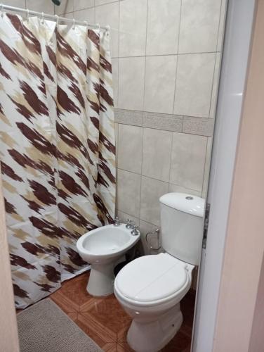 a bathroom with a toilet and a shower curtain at Margarita in Oberá