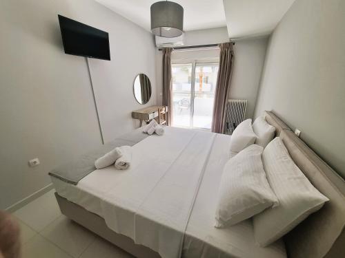 a large white bed in a room with a television at Rethymno Holiday in Áyios Andónios
