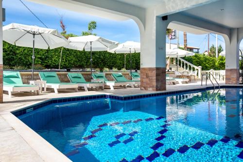 a swimming pool with chairs and umbrellas on a patio at Garden in Limenaria