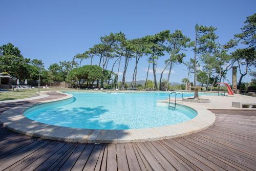 a swimming pool in a park with a wooden deck at Liiiving in Ofir - Seaside Pool Bungalow in Fão