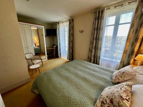 a hotel room with a bed and a window at L'Oustal Del Barry in Najac