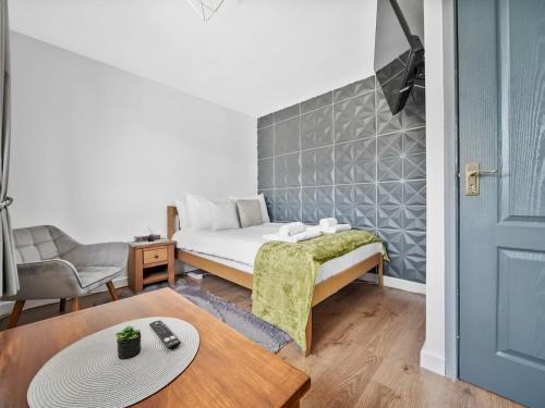 a small bedroom with a bed and a table at Pass the Keys Spacious Garden Family House - Marks Gate in Romford