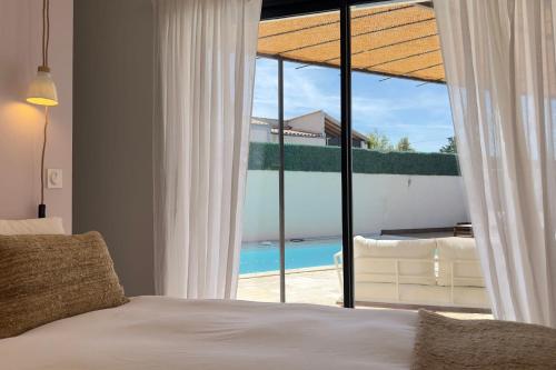 une chambre avec un lit et une vue sur l'océan dans l'établissement La villa des Gypières, à LʼIsle-sur-la-Sorgue