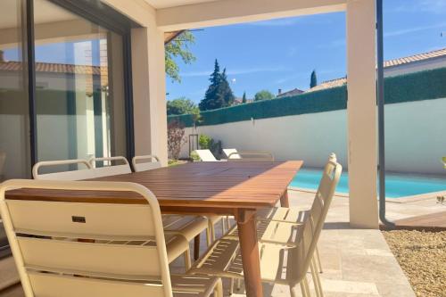 une salle à manger avec une table et des chaises en bois dans l'établissement La villa des Gypières, à LʼIsle-sur-la-Sorgue