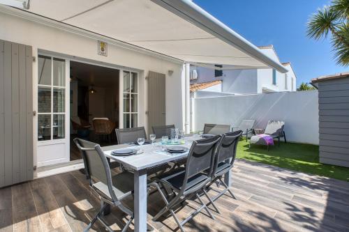 Une table à manger et des chaises sont disponibles sur la terrasse. dans l'établissement 219 Thoiras 6 House, garden and parking, à Saint-Martin-de-Ré