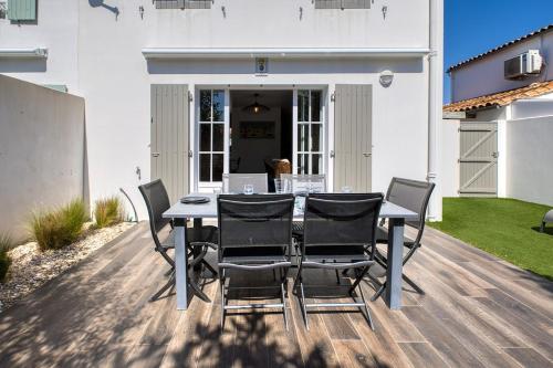 un patio avec une table et des chaises sur une terrasse dans l'établissement 219 Thoiras 6 House, garden and parking, à Saint-Martin-de-Ré