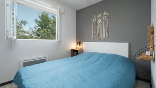 une chambre avec un lit bleu et une fenêtre dans l'établissement La Dune N 51 - VILLA 2P4, à Sérignan
